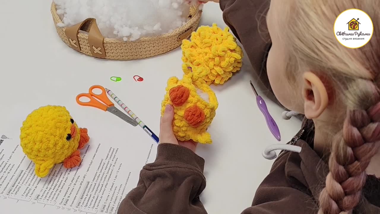 Ребенок вяжет игрушку из пряжи с петельками